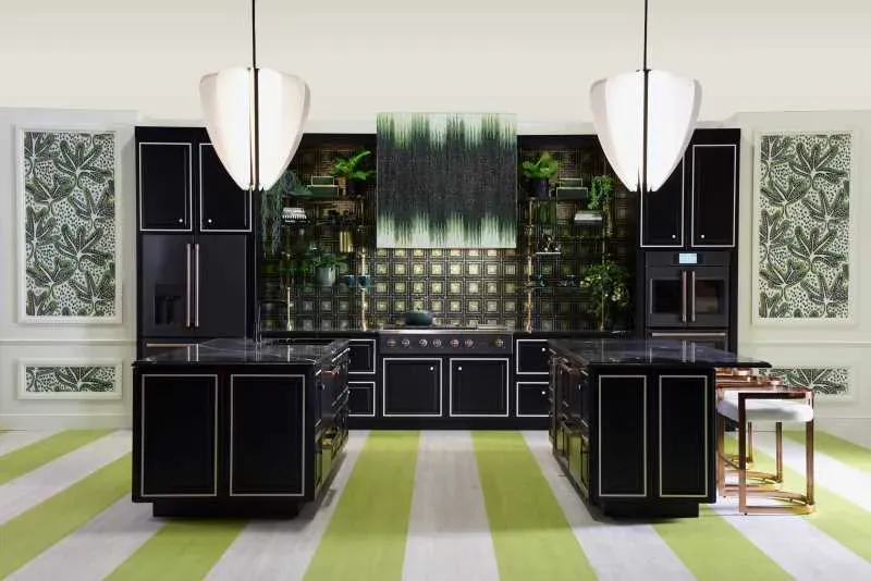 A striking kitchen with green and white wallpaper and rugs, highlighting the black cabinetry with white accents.